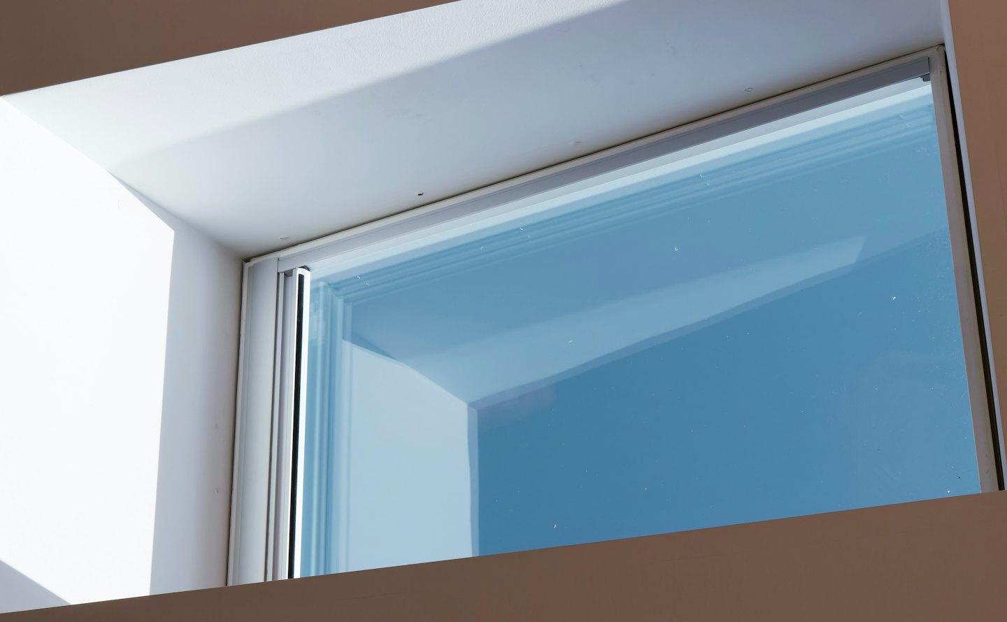 Modern window frame showing a clear blue sky.