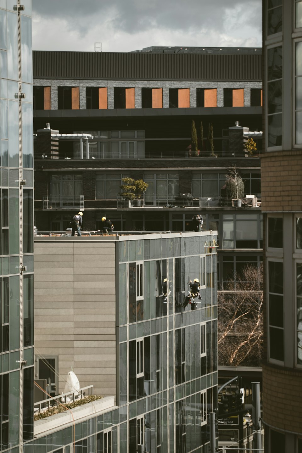 Workers cleaning windows on a modern high-rise building.